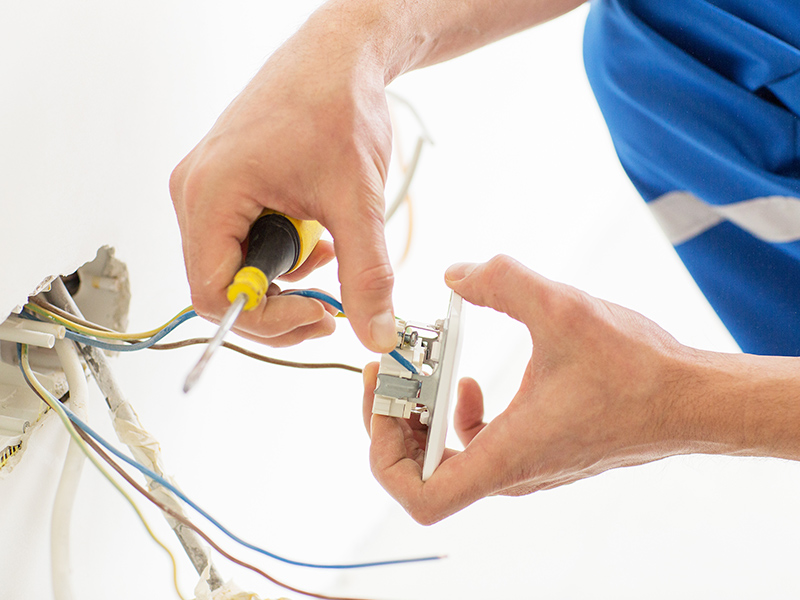 electrician-hands-close-up-repairing-wall-outlet-pasadena-md Residential Electrician in Annapolis, MD